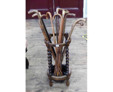 Circular oak barley twist stick stand and collection of walking sticks (stick stand 62cm by 33cm diameter).