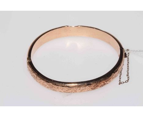 9 carat gold hinged bangle with engraved decoration.