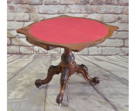 MID-VICTORIAN BURR WALNUT SERPENTINE CARD TABLE, fold-over top, red baize playing surface, carved column on fruit and leaf ca
