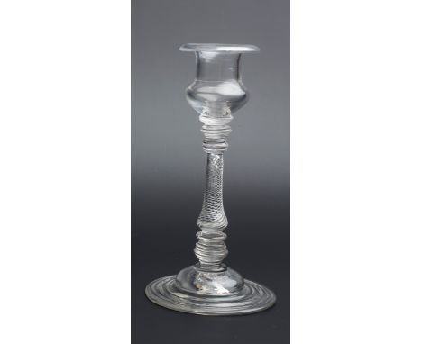 AN ANTIQUE GLASS CANDLESTICK with baluster air twist column and stepped domed foot, 20cm high