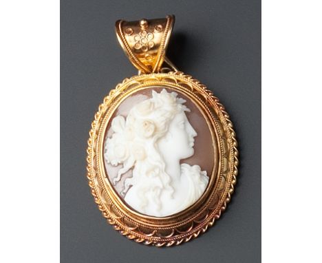 A VICTORIAN OVAL SHELL CAMEO PENDANT, carved to depict the portrait profile of a classical bacchante, to ropetwist wirework d