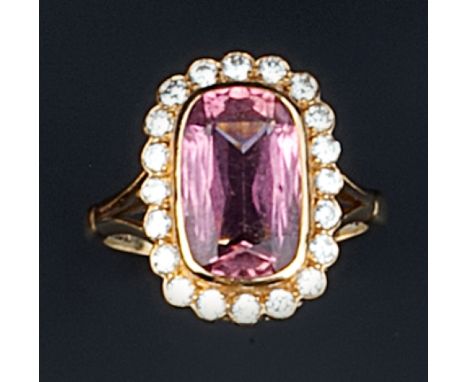 A PINK TOURMALINE AND DIAMOND CLUSTER RING, the cushion-shaped pink tourmaline collet set within a border of brilliant-cut di