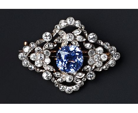 A SAPPHIRE AND DIAMOND PANEL BROOCH, the cushion-shaped mixed-cut sapphire claw set within an openwork lozenge-shaped frame, 