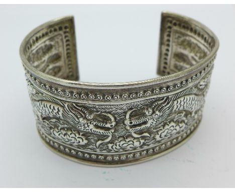 A silver embossed dragon bangle