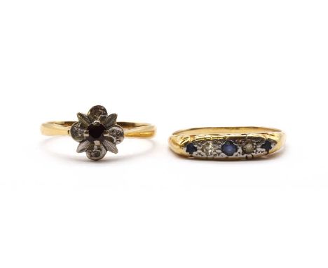 An 18ct gold ruby and diamond cluster ring,a round mixed cut ruby claw set at the centre, with a quatrefoil of eight cut diam