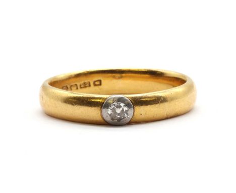 A 22ct gold wedding ring, with an old European cut diamond later set to the band, rub set to a white metal collet, ring hallm