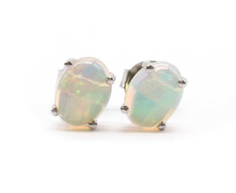 A pair of silver single stone opal stud earrings, with an oval cabochon opal, approximately 8 x 6mm, claw set to post and but