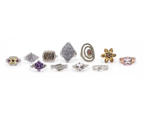 A collection of silver gem-set rings, to include a brown and white diamond cluster ring, two diamond set crossover rings, a t
