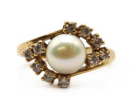 A gold cultured pearl and diamond ring, a cultured pearl, cup set, to crossover shoulders claw set with brilliant cut diamond