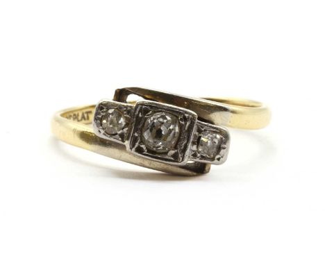 A gold three stone diamond ring, a row of old cut diamonds, grain set to box collets, to crossover shoulders and a plain shan