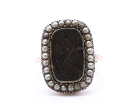 A gold memorial ring, woven hair to a glazed panel, with a border of split pearls, with engraved initials to the underside of