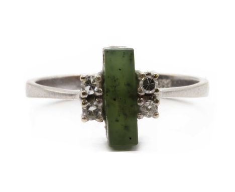 A white gold nephrite jade and diamond ring, a nephrite jade plaque with a pair of eight cut diamonds claw set at each side, 