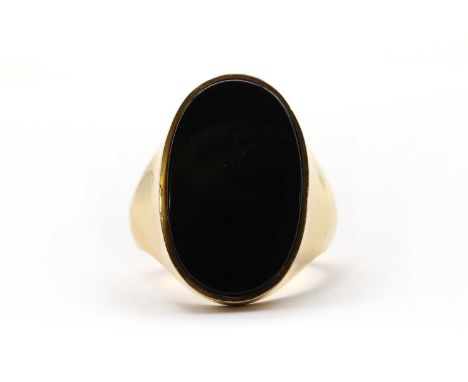 A large gold onyx ring,an onyx table, rub set to tapering shoulders and a 'D' section shank, tested as approximately 18ct gol