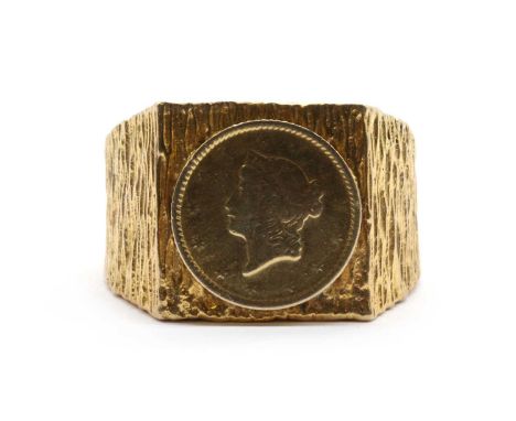 A gentlemen's gold ring, with a coin style plaque applied to the square head, with a textured mount, tested as approximately 