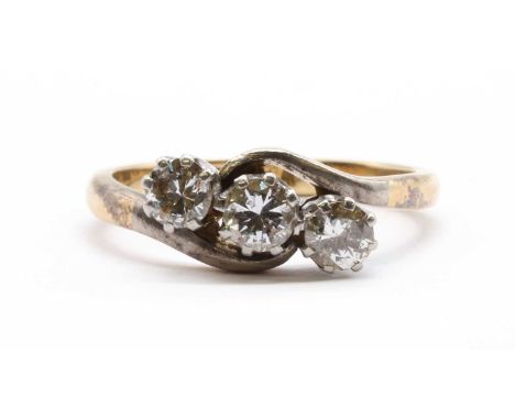 A gold three stone diamond ring, a row of brilliant cut diamonds claw set to rex collets, to crossover shoulders and a 'D' se