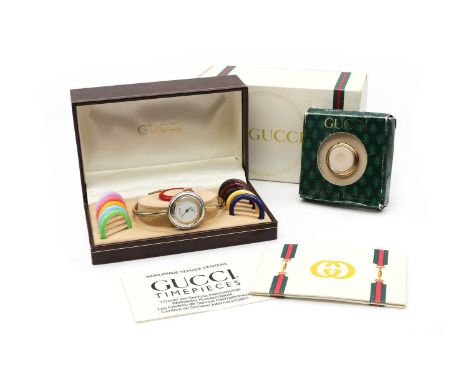 A ladies' gold plated Gucci quartz bangle watch,model no. 1100-L, a circular white dial with gilt hands and a white metal det