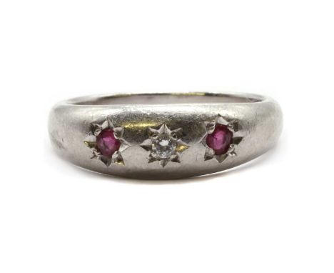 A platinum three stone diamond and ruby ring, a brilliant cut diamond with a round mixed cut ruby at each side, all star set 