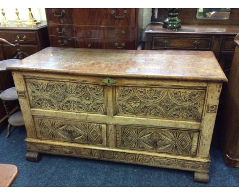 An eighteenth century oak chest with two drawers to base, a carved, decorated panel to front and a later oak lid.
