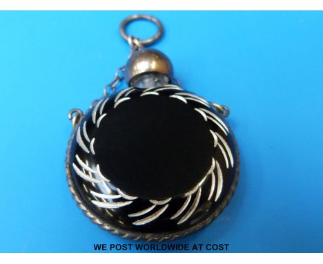 An overlaid and cut glass circular scent bottle, the black glass with white underlay, white metal rope twist surround, top an