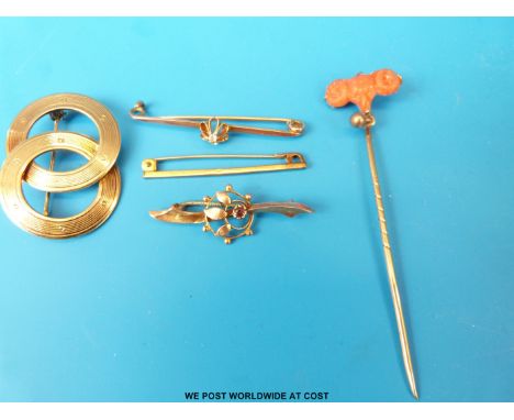 A 9ct gold brooch set with a garnet, two yellow metal brooches, one set with a diamond, a stick pin and a gold plated brooch 