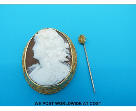 A large cameo brooch depicting a neoclassical figure in yellow metal surround together with 15ct gold stick pin