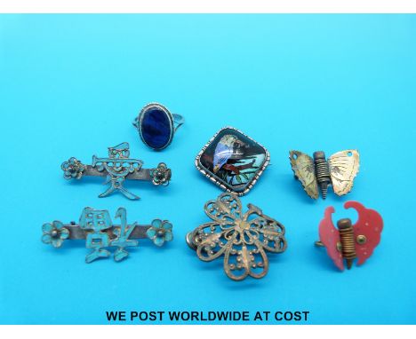 Two white metal brooches in the form of Chinese characters both set with kingfisher wing, a silver ring set with butterfly wi