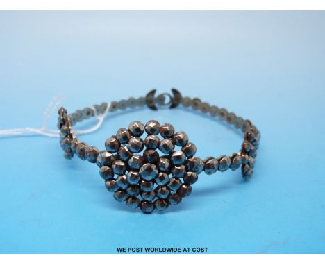 A Victorian cut steel bangle formed of a row of single faceted stones and three circular sections 