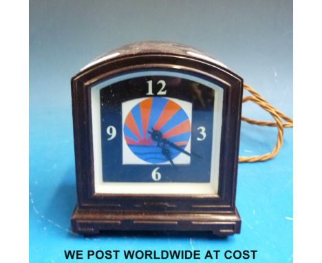 An Art Deco bakelite electric alarm clock, the dial with sunset decoration