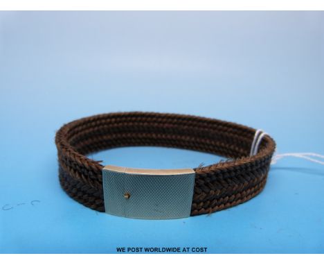 A 19thC plaited hair bracelet, the yellow metal clasp with engine turned decoration 