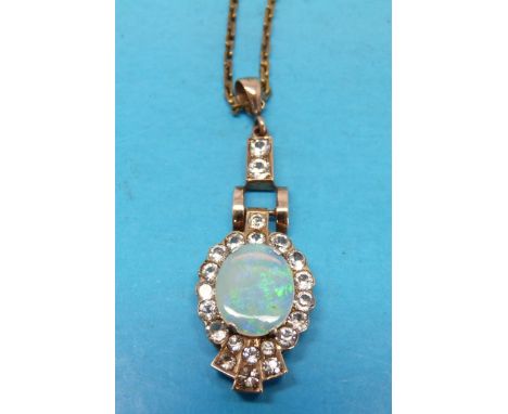 A yellow metal pendant set with a large opal surrounded by cubic zirconia 