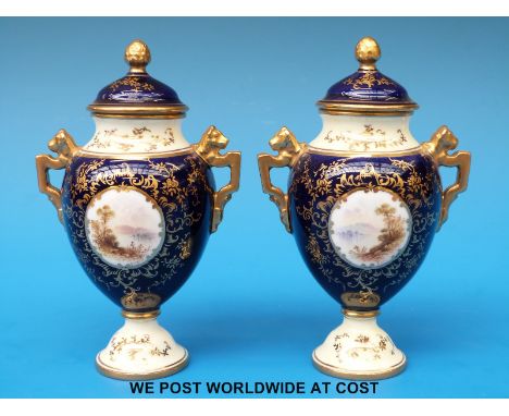 A pair of Coalport covered pedestal vases hand decorated with lake scenes and lion finial handles (height 12cm)