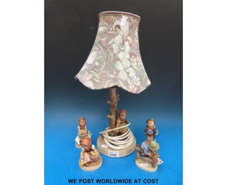 A collection of four Goebel Hummel figures and a table lamp