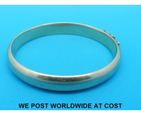 A yellow metal bangle marked 585 (30.9g)