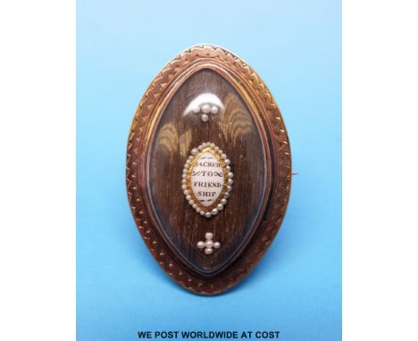 A 19thC yellow metal marquise shaped brooch inset with hair and a small plaque to the centre reading "Sacred to friendship" w