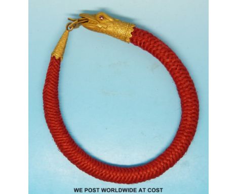 A 19thC plaited horse hair bracelet with a yellow metal clasp in the form of a serpent's head with inset ruby eyes  