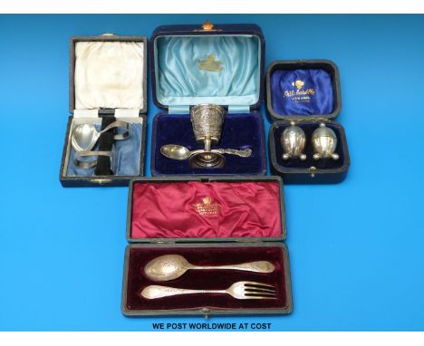Four cased hallmarked silver sets comprising fork and spoon christening set, spoon and pusher, pair of peppers and a spoon an