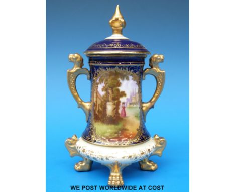 A Coalport twin handled covered vase with hand decorated cartouche of a lady in a garden, probably 'Rendezvous', lion finial 