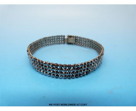 A Georgian/ early Victorian cut steel and white metal bangle formed of four rows of single faceted stones 