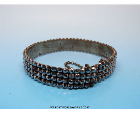 A Victorian cut steel bangle made up of four rows of circular faceted stones 