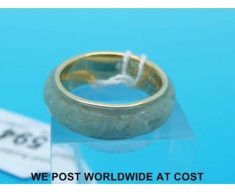 A yellow metal ring set with carved jade (size S)