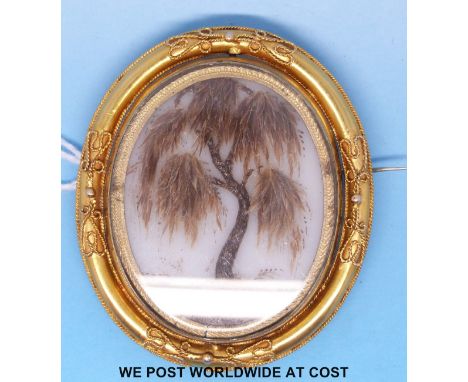 A 19thC swivel mourning brooch, one side with sections of hair depicting a tree, a daguerreotype portrait of a man verso 