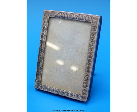 A small engine turned hallmarked silver photograph frame to suit 3 x 2" photograph and with fold out stand to rear. Birmingha