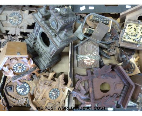 A carved mantel cuckoo clock case and several other cuckoo clocks with some spare parts and some weights 