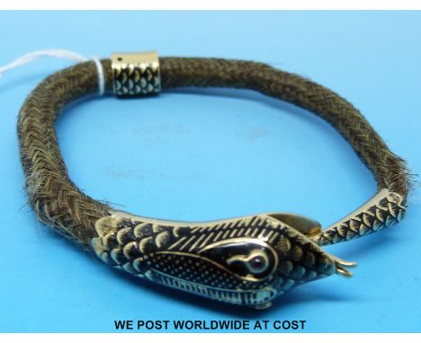 A 19thC plaited hair bangle with a yellow metal and Champlevé enamel clasp in the form of a snake set with garnet eyes 