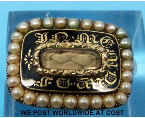 A Georgian yellow metal brooch set with a central panel of plaited hair surrounded by black enamel 'In Memory Of' and a borde