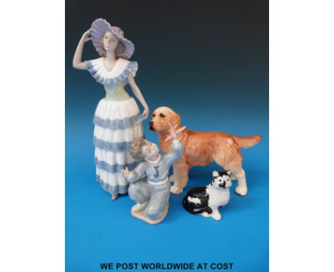 A large Nao figurine of a lady holding her hat, Nao child with toy aeroplane, a dog and cat figures