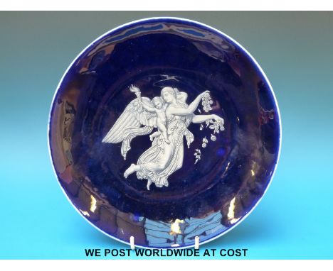 A Worcester Porcelain Works pate sur pate, charger by Bott with hand decorated scene of an angel carrying a cherub with flami