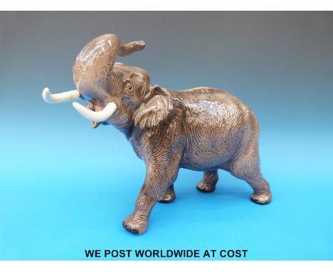 A large Beswick elephant charging with trunk raised (30cm tall)