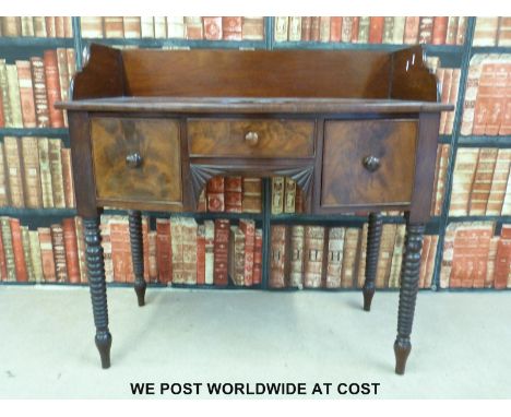 A Victorian mahogany washstand with two drawers flanking a central false drawer, raised on bobbin turned legs (W98cm x D55cm 