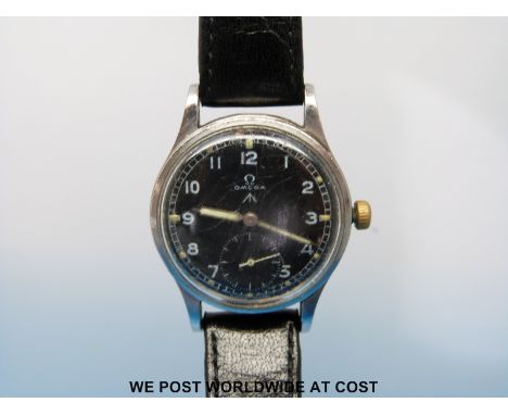 A military Omega gentleman's wristwatch the black face with subsidiary seconds dial and luminous hands and markers, the stain